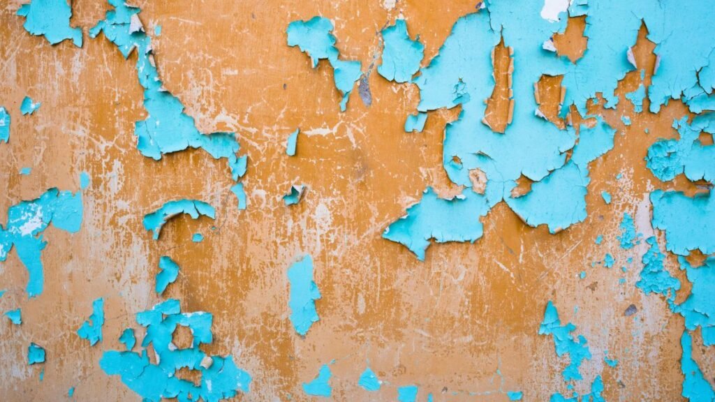 Close-up of peeling paint on a bathroom wall caused by moisture and humidity